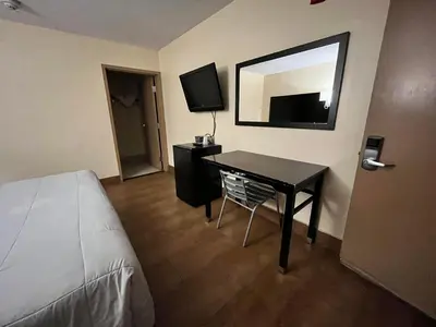 a bedroom with a desk and a bed and a mirror at Circle Motor Lodge in South Amboy