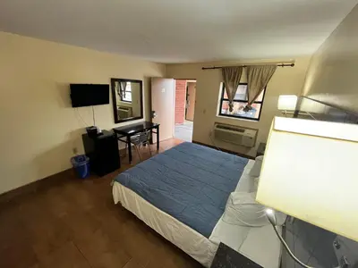 a bedroom with a bed and a desk in it at Circle Motor Lodge in South Amboy