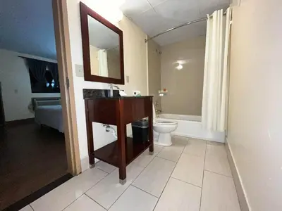 a bathroom with a sink and a toilet and a mirror at Circle Motor Lodge in South Amboy