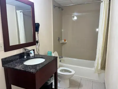 a bathroom with a sink and a toilet and a mirror at Circle Motor Lodge in South Amboy