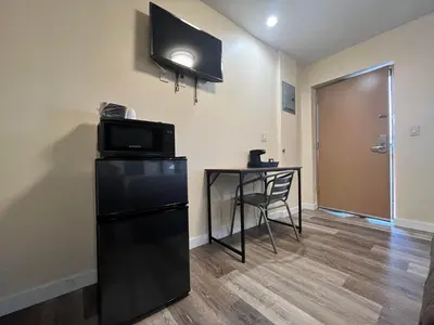 a room with a small table and a black refrigerator at Circle Motor Lodge in South Amboy
