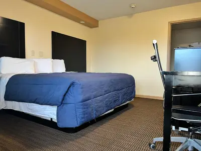 a bed in a hotel room with a blue blanket at Circle Motor Lodge in South Amboy