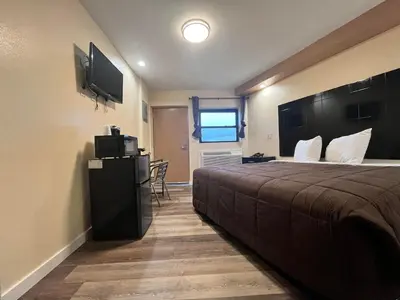 a hotel room with a bed and a flat screen tv at Circle Motor Lodge in South Amboy