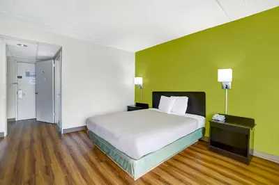 a bedroom with a bed and a green wall at Motel 6-Lawrenceville, NJ in Lawrenceville