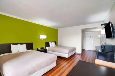 a hotel room with two beds and a flat screen tv at Motel 6-Lawrenceville, NJ in Lawrenceville