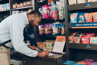 a man in a store looking at a shelf with food at Candlewood Suites Bensalem - Philadelphia Area by IHG in Bensalem