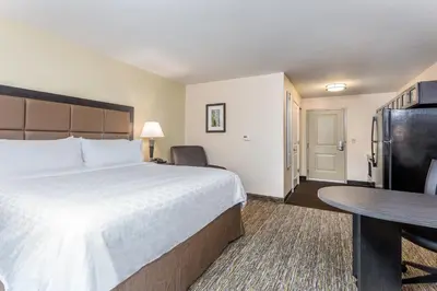 a hotel room with a large bed and a table at Candlewood Suites Bensalem - Philadelphia Area by IHG in Bensalem
