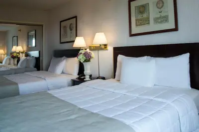 a hotel room with two beds and two lamps at Meadowlands Plaza Hotel in Secaucus