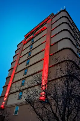 a tall building with red lights on it at Meadowlands Plaza Hotel in Secaucus