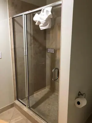 a shower with a glass door in a bathroom at Grand Eastonian Hotel & Suites in Easton