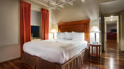 a bedroom with a large bed and two lamps at Grand Eastonian Hotel & Suites in Easton