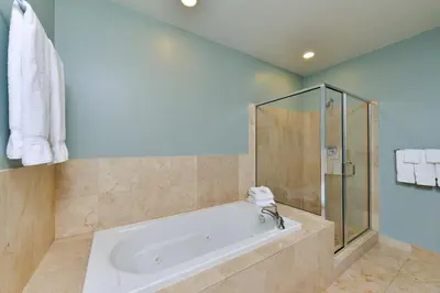 a bathroom with a tub and a shower at Grand Eastonian Hotel & Suites in Easton