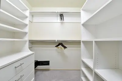 a walk in closet with white cabinets at Grand Eastonian Hotel & Suites in Easton