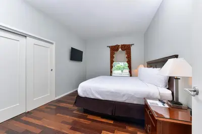 a bedroom with a bed and a table with a lamp at Grand Eastonian Hotel & Suites in Easton