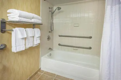a bathroom with a white tub and towels at Baymont by Wyndham Harrisburg in Harrisburg