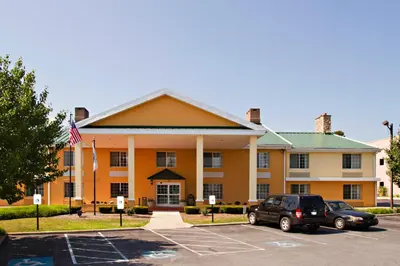 a building with a car parked in a parking lot at Baymont by Wyndham Harrisburg in Harrisburg
