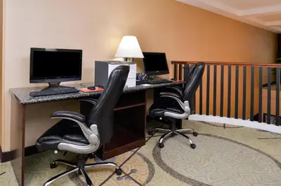 a hotel room with two computer desks with chairs at Holiday Inn Express Hotel & Suites West Chester by IHG in West Chester