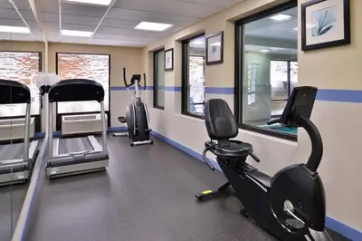 a gym with several treadmills and elliptical machines at Holiday Inn Express Hotel & Suites West Chester by IHG in West Chester