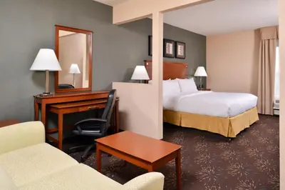 a hotel room with a bedroom with a bed and a desk at Holiday Inn Express Hotel & Suites West Chester by IHG in West Chester