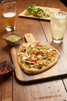 a pizza sitting on top of a wooden table at Hyatt Place Bethlehem-Downtown in Bethlehem