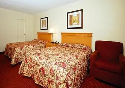 a hotel room with two beds and a red chair at Inn at Monticello in Monticello