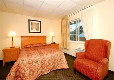 a hotel room with a bed and a chair at Inn at Monticello in Monticello