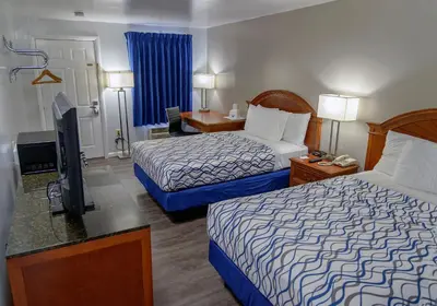 a hotel room with two beds and a flat screen tv at America's Best Value Inn Lancaster in Lancaster