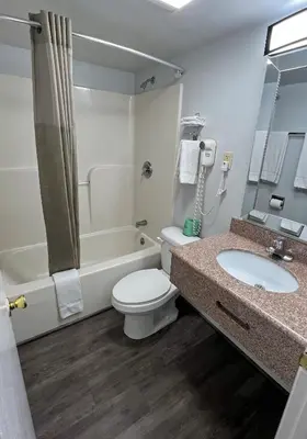 a bathroom with a toilet and a tub and a sink at America's Best Value Inn Lancaster in Lancaster