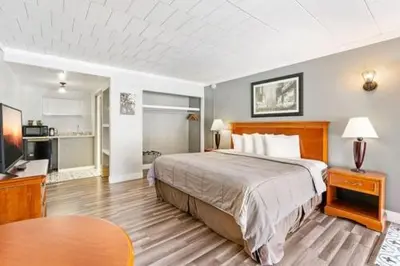 a bedroom with a bed and a desk and a table at FairBridge Inn and Suites West Point in Highland Falls