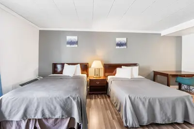 a hotel room with two beds and a table at FairBridge Inn and Suites West Point in Highland Falls