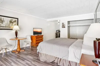 a bedroom with a bed and a desk and a table at FairBridge Inn and Suites West Point in Highland Falls