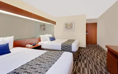 a hotel room with two beds and a tv at Microtel Inn & Suites by Wyndham Middletown in Middletown