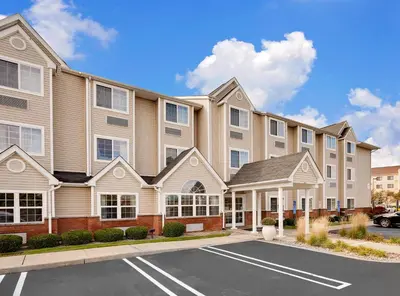 a large apartment building with a parking lot at Microtel Inn & Suites by Wyndham Middletown in Middletown