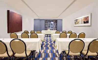 a conference room with tables and chairs and a podium at Microtel Inn & Suites by Wyndham Middletown in Middletown