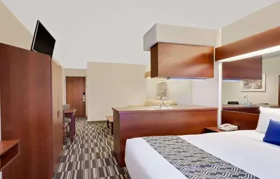 a hotel room with a bed and a sink at Microtel Inn & Suites by Wyndham Middletown in Middletown