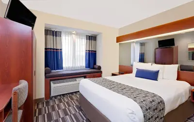 a hotel room with a bed and a television at Microtel Inn & Suites by Wyndham Middletown in Middletown