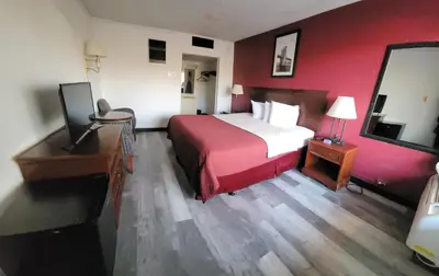 a hotel room with a bed with a red wall at Newburgh Inn in Newburgh
