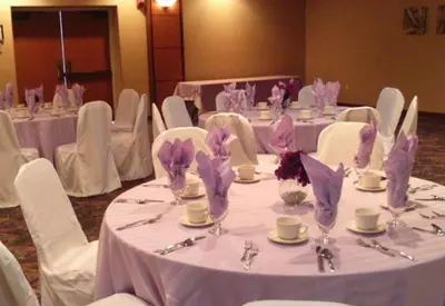 a room with white tables and chairs with purple napkins at Newburgh Inn in Newburgh