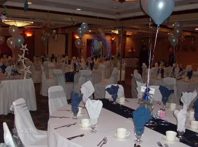a banquet hall with white tables and blue balloons at Newburgh Inn in Newburgh