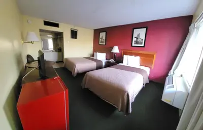 a hotel room with two beds and a flat screen tv at Newburgh Inn in Newburgh
