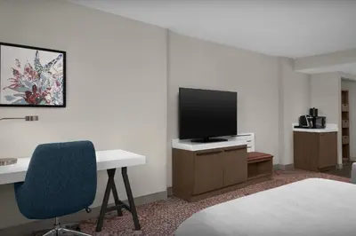 a room with a desk and a flat screen tv at Hilton Garden Inn Philadelphia-Fort Washington in Fort Washington