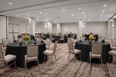 a conference room with tables and chairs with flowers on them at Hilton Garden Inn Philadelphia-Fort Washington in Fort Washington