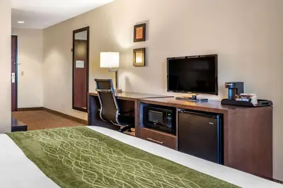 a hotel room with a bed and a flat screen tv at Comfort Inn Williamsport in Williamsport