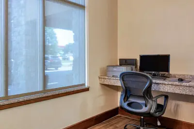 a desk with a computer and a chair next to a window at Comfort Inn Williamsport in Williamsport