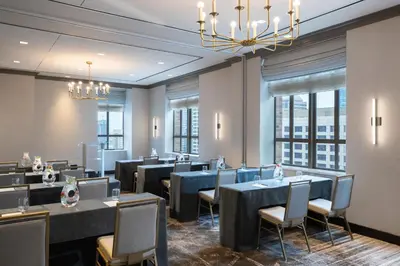 a dining room with tables and chairs and a chandelier at Kimpton Hotel Palomar Philadelphia by IHG in Philadelphia