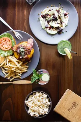 three plates of food on a wooden table at Kimpton Hotel Palomar Philadelphia by IHG in Philadelphia