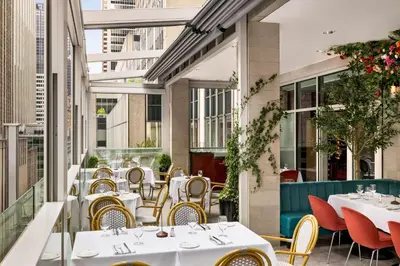 a restaurant with tables and chairs on a balcony at DoubleTree by Hilton New York Midtown Fifth Ave in New York