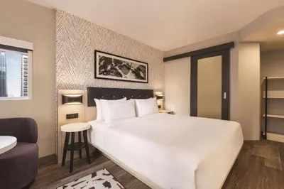 a bedroom with a large white bed and a chair at DoubleTree by Hilton New York Midtown Fifth Ave in New York