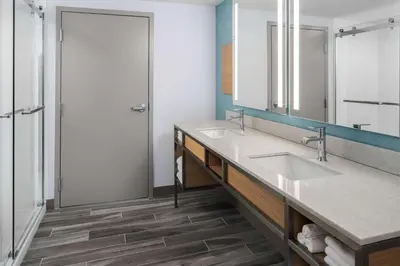 a bathroom with two sinks and a shower at Hilton Garden Inn Rockaway in Rockaway