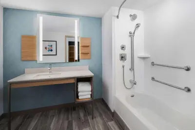 a bathroom with a sink and a tub and a mirror at Hilton Garden Inn Rockaway in Rockaway